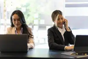 Duas recepcionistas trabalhando em sua mesa